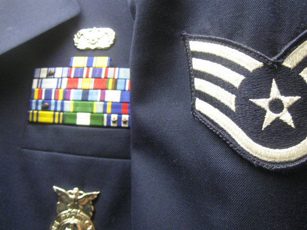 U.S. Air Force service dress uniform with Staff Sergeant rank insignia, service ribbons, and Security Forces badge